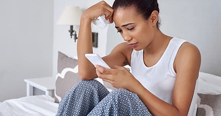 Woman sitting looking at mobile device
